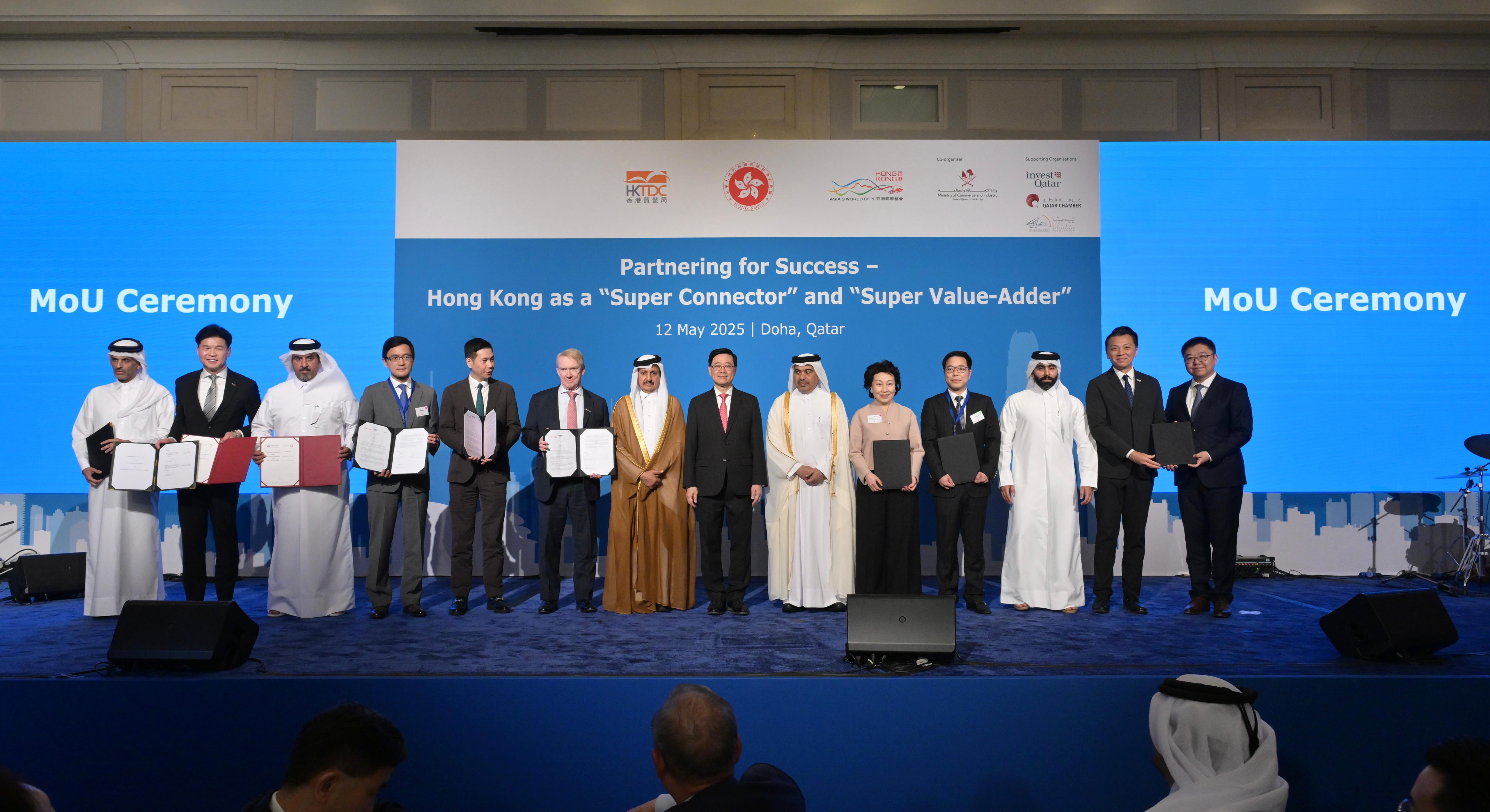 HKSAR's Chief Executive John Lee (seventh right) witnesses agreements signed between government department, enterprises, and institutions from Hong Kong, Mainland China and Qatar.