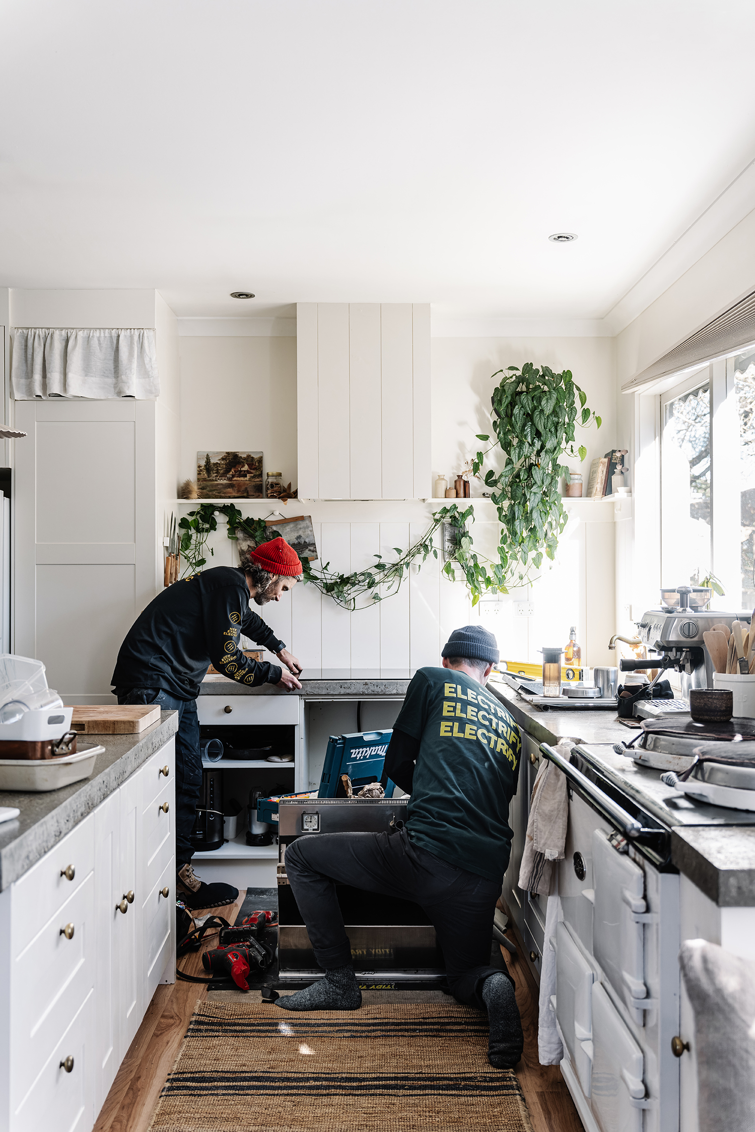 Electric appliances being installed in a bright, modern kitchen.